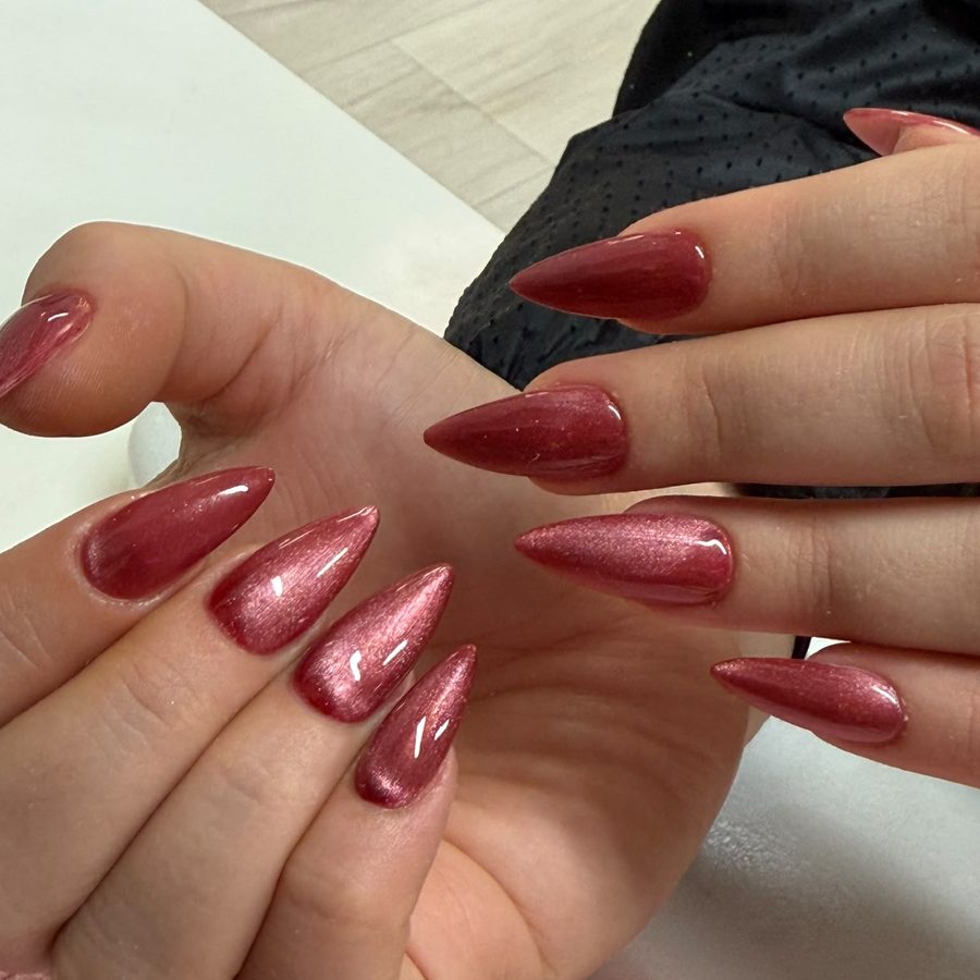 Cat-Eye-Gellack in schimmerndem Beerenrot auf spitzen Stiletto-Nägeln